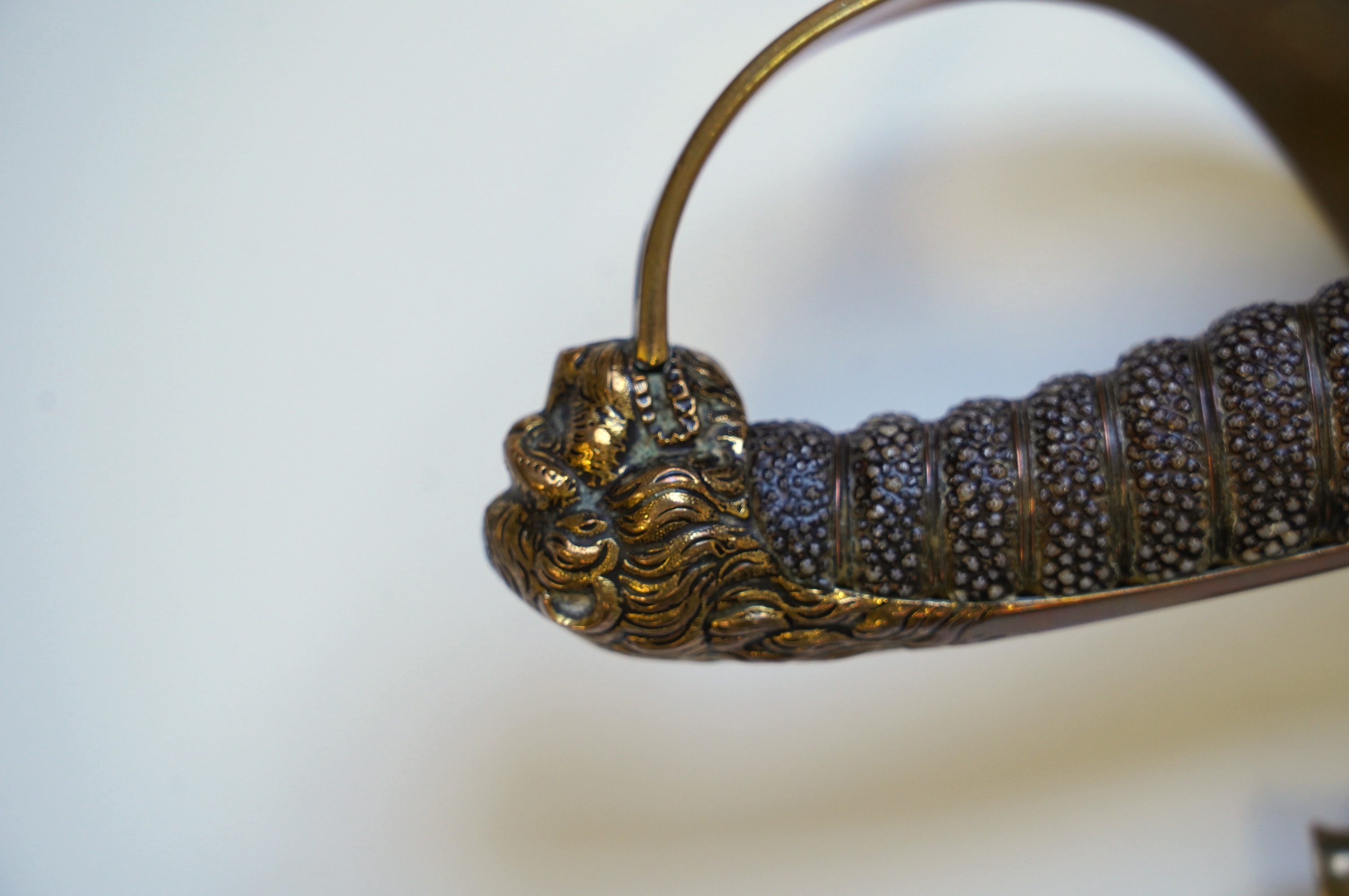 An early 19th century Royal Navy officer's sword with engraved blade, folding knuckle guard, lion’s head pommel and shagreen grip, leather scabbard with brass fittings, blade 73.5cm. Condition - fair, some wear overall.